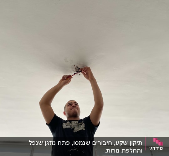 חשמלאי עובד על תקרה עם כלי עבודה